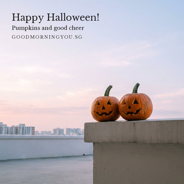 Two carved jack-o'-lanterns side by side on a concrete parapet with HDB blocks beyond under a pink dawn sky, and the words "Happy Halloween! Pumpkins and good cheer"