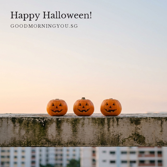 Three carved jack-o'-lantern pumpkins in a row on a concrete HDB parapet under a soft peach dawn sky, with blurred HDB blocks below and the words "Happy Halloween!"